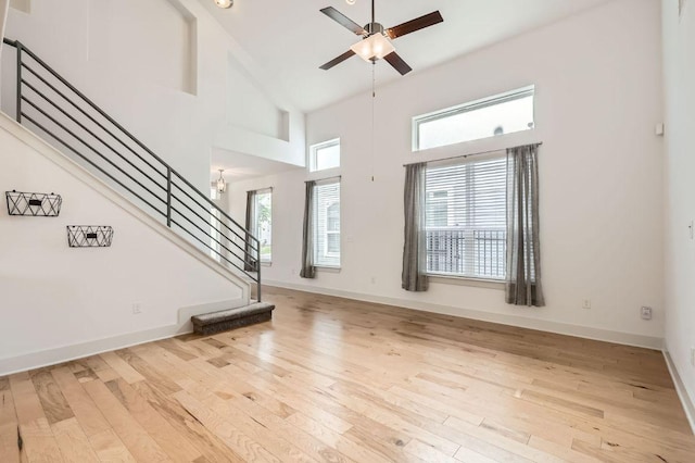 1513 Casa Dr, Austin, TX 78745 - unfurnished living room with stairs, high vaulted ceiling, wood finished floors, ceiling fan, and baseboards