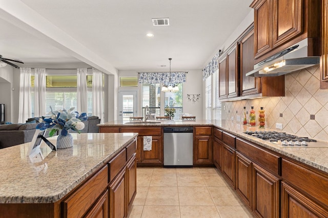 2812 Saint Rodrigo Ct, Round Rock, TX 78665 - kitchen with stainless steel appliances, open floor plan, tasteful backsplash, under cabinet range hood, and a peninsula