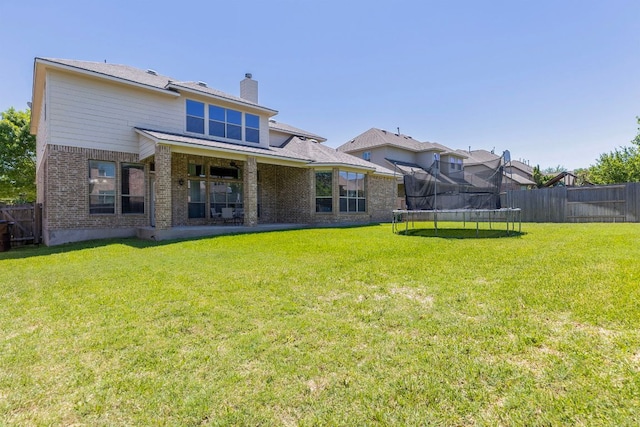 2812 Saint Rodrigo Ct, Round Rock, TX 78665 - back of house featuring a trampoline, brick siding, a fenced backyard, and a chimney