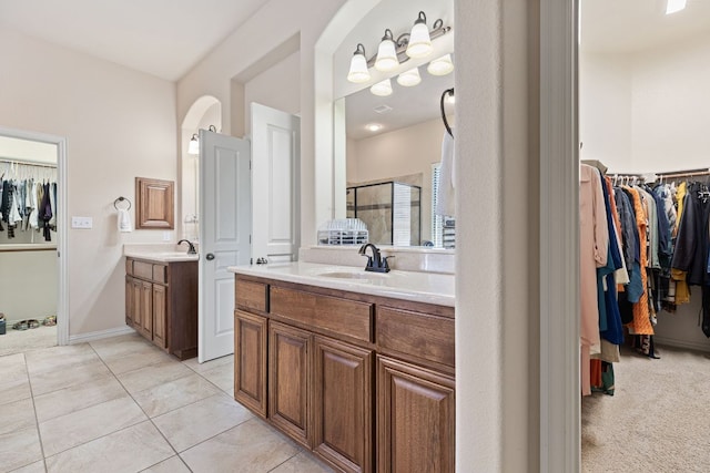 2812 Saint Rodrigo Ct, Round Rock, TX 78665 - bathroom with a walk in closet, two vanities, a shower stall, and tile patterned floors