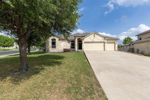 2129 Aaron Ross Way, Round Rock, TX 78665 - view of front of home featuring driveway, an attached garage, a front lawn, and stone siding