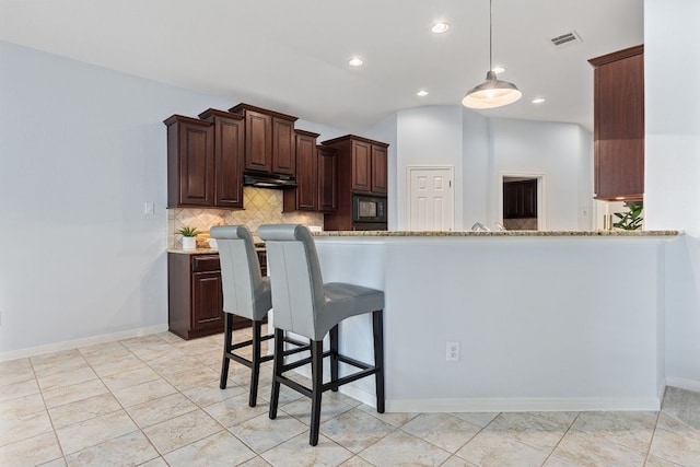 2129 Aaron Ross Way, Round Rock, TX 78665 - kitchen with under cabinet range hood, tasteful backsplash, recessed lighting, pendant lighting, and light stone counters