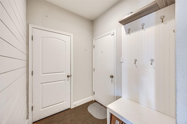 mudroom with dark wood finished floors and baseboards