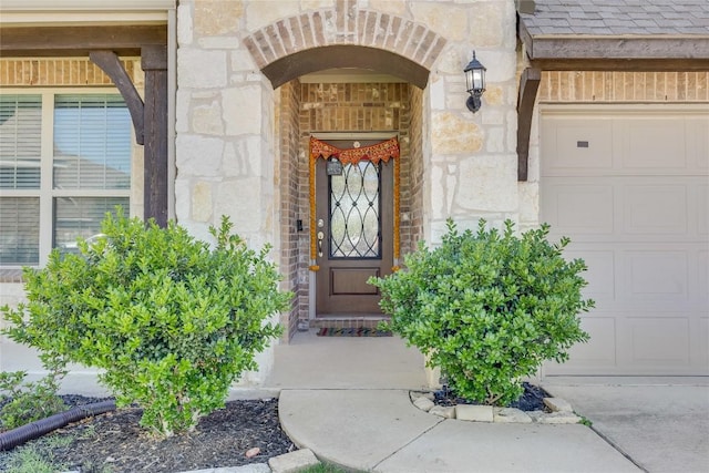 entrance to property featuring stone siding and an attached garage
