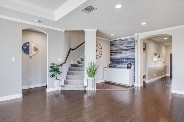 interior space with recessed lighting, stairway, visible vents, arched walkways, and wood finished floors