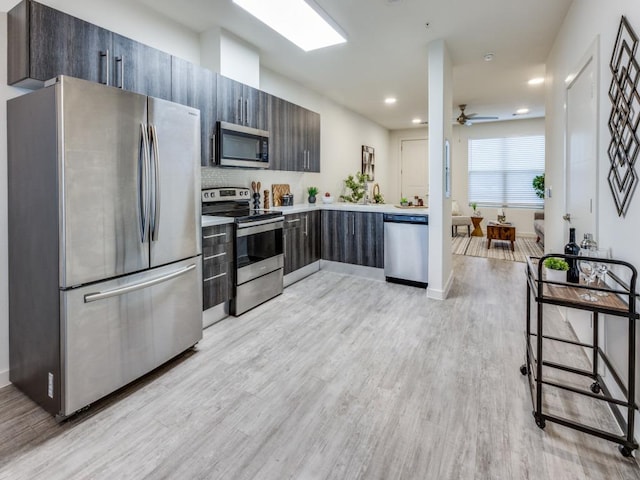 7805 Cooper Ln Unit 103, Austin, TX 78745 - kitchen with light wood finished floors, light countertops, a ceiling fan, modern cabinets, and appliances with stainless steel finishes