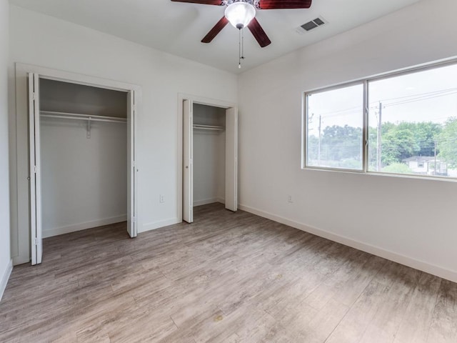 7805 Cooper Ln Unit 103, Austin, TX 78745 - unfurnished bedroom featuring multiple windows, visible vents, light wood-style flooring, and multiple closets