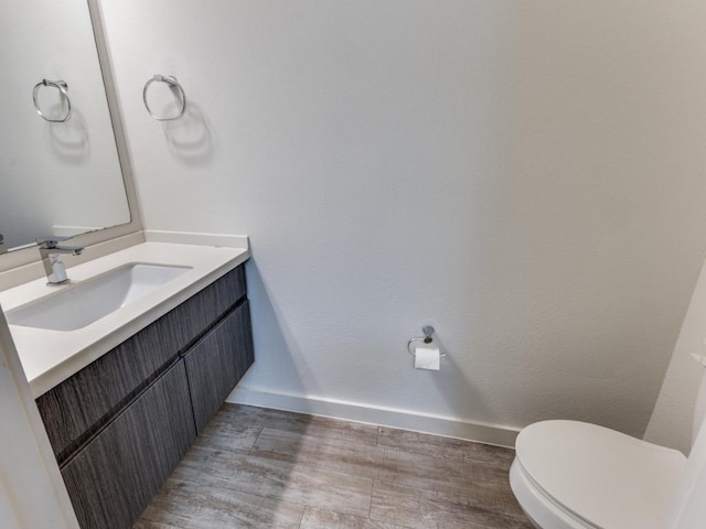 7805 Cooper Ln Unit 103, Austin, TX 78745 - half bath with baseboards, vanity, toilet, and wood finished floors