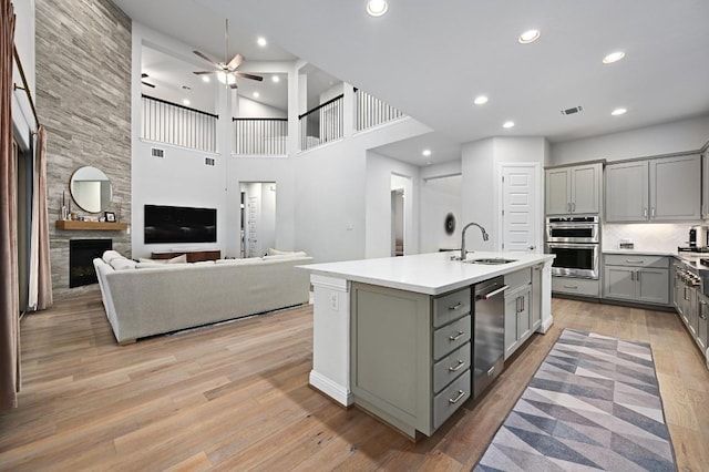 233 Abbeyville Walk, Austin, TX 78738 - kitchen featuring gray cabinetry, stainless steel appliances, ceiling fan, a sink, and an island with sink