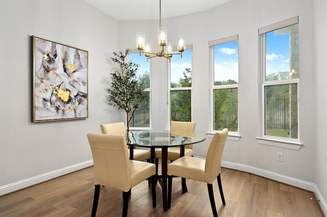 233 Abbeyville Walk, Austin, TX 78738 - dining space with a chandelier, wood finished floors, healthy amount of natural light, and baseboards
