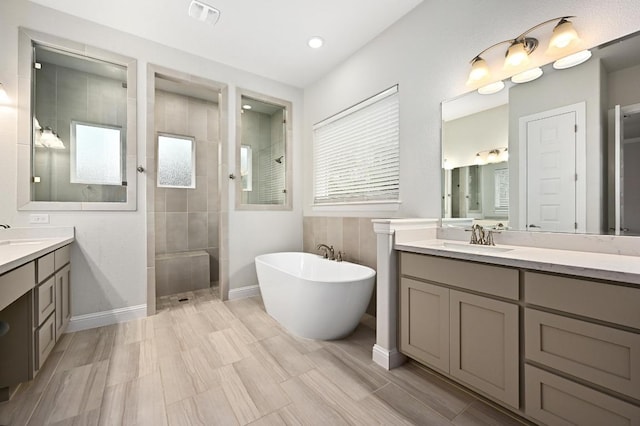 233 Abbeyville Walk, Austin, TX 78738 - full bathroom with a walk in shower, two vanities, a freestanding bath, and baseboards