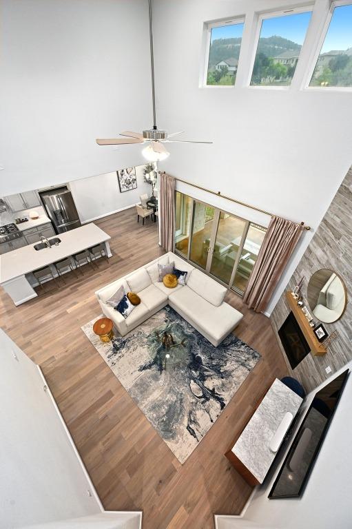 233 Abbeyville Walk, Austin, TX 78738 - living area featuring healthy amount of natural light, wood finished floors, and a high ceiling