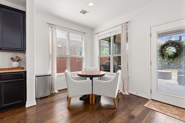 dining area featuring visible vents, dark wood-style flooring, and baseboards