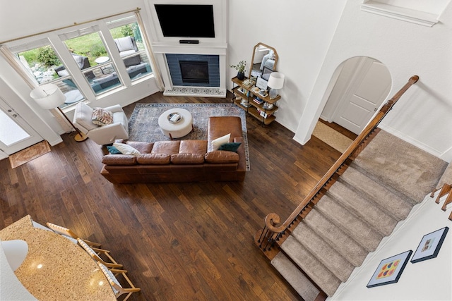 living room featuring baseboards, wood finished floors, and a glass covered fireplace