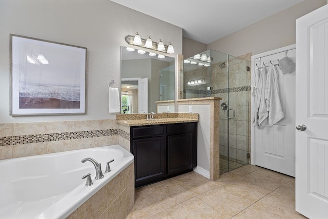 bathroom with tile patterned flooring, vanity, a bath, and a stall shower