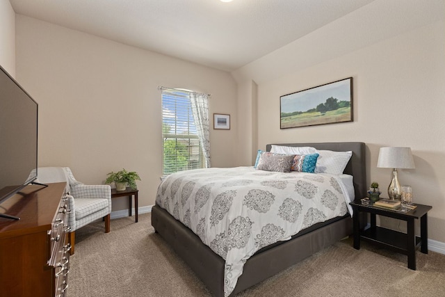 carpeted bedroom with baseboards and lofted ceiling