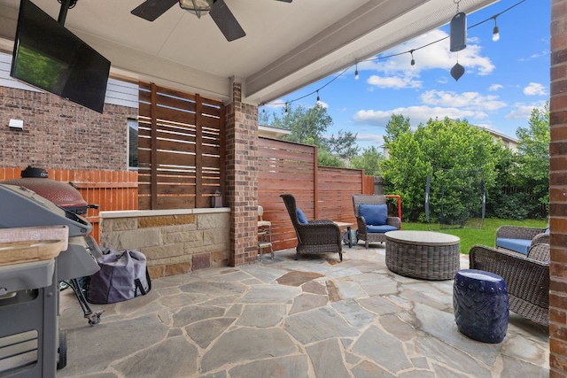 view of patio with ceiling fan and fence