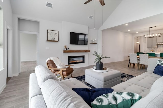 1109 Sweetspire St, Leander, TX 78641 - living room featuring a glass covered fireplace, light wood-style floors, a ceiling fan, baseboards, and recessed lighting