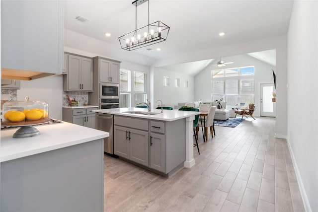 1109 Sweetspire St, Leander, TX 78641 - kitchen featuring gray cabinetry, a sink, appliances with stainless steel finishes, light countertops, and open floor plan