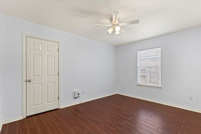 spare room featuring baseboards, wood finished floors, and ceiling fan