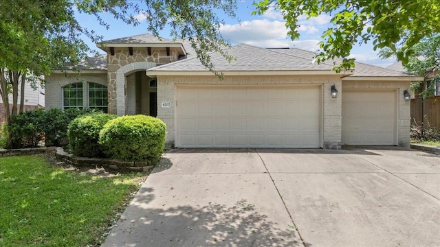 view of front of house with concrete driveway, a garage, a shingled roof, and brick siding