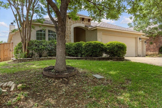mediterranean / spanish-style house with a front yard, driveway, an attached garage, and brick siding