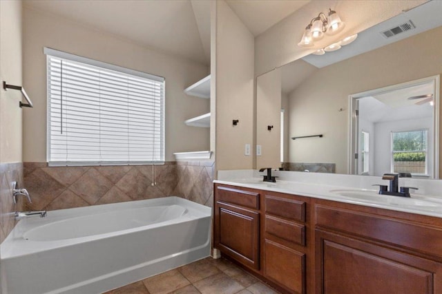 bathroom featuring visible vents, double vanity, a bath, and a sink