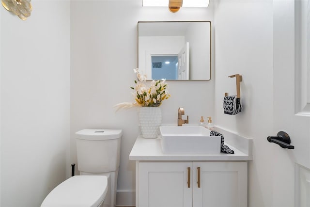 half bath featuring vanity and toilet
