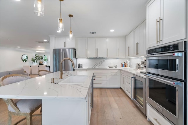 11009 Midbury Ct, Austin, TX 78748 - kitchen with white cabinetry, stainless steel appliances, visible vents, and a sink