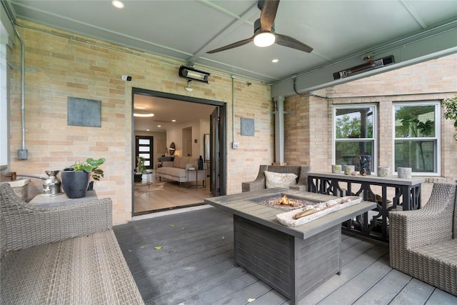 deck featuring a ceiling fan and an outdoor fire pit