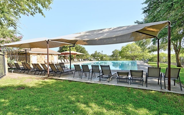pool featuring a lawn, fence, and a patio area