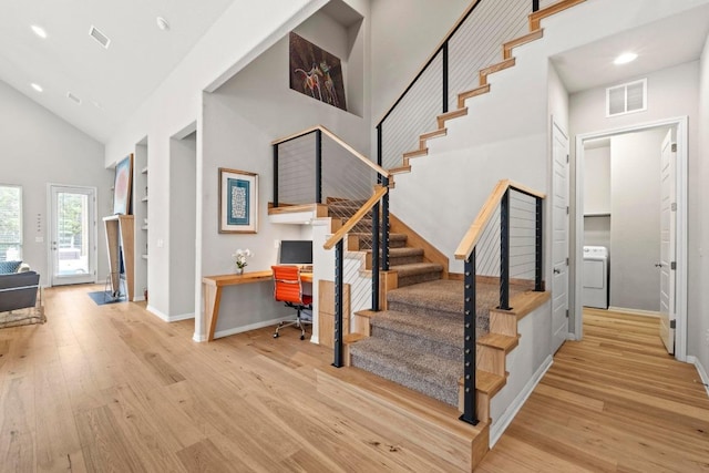 2420 Soprano Way, Round Rock, TX 78681 - staircase with visible vents, washer / dryer, wood finished floors, and high vaulted ceiling