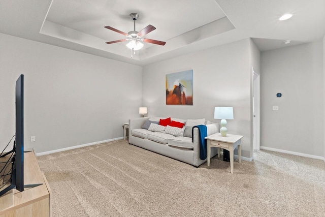 2420 Soprano Way, Round Rock, TX 78681 - living area featuring carpet floors, a ceiling fan, a tray ceiling, and baseboards