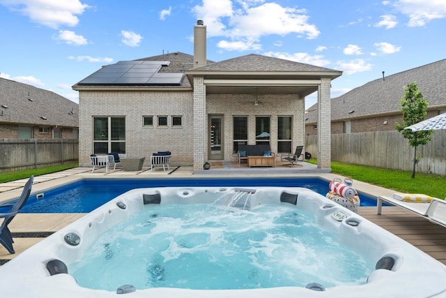 2420 Soprano Way, Round Rock, TX 78681 - rear view of property featuring brick siding, a jacuzzi, and roof mounted solar panels
