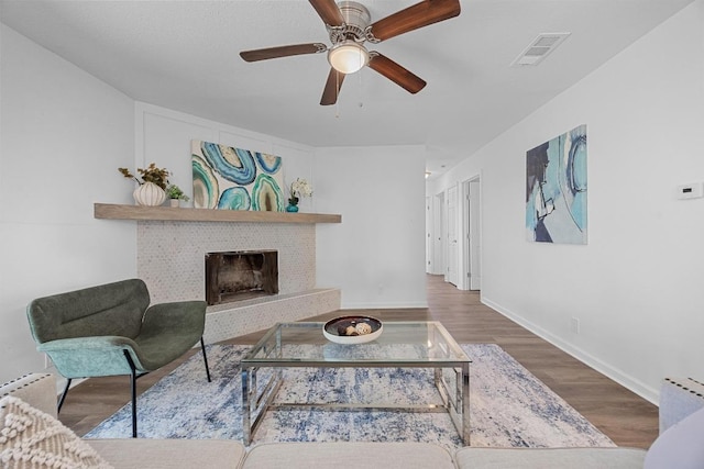 2111 Mardean Ln, Temple, TX 76501 - living area featuring wood finished floors, ceiling fan, a fireplace, baseboards, and visible vents