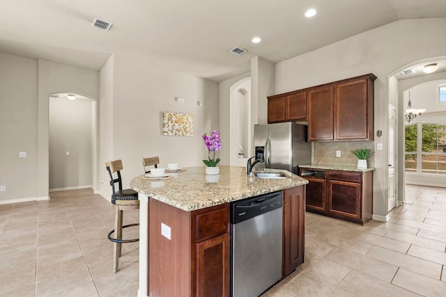 kitchen featuring visible vents, stainless steel appliances, arched walkways, and light tile patterned floors