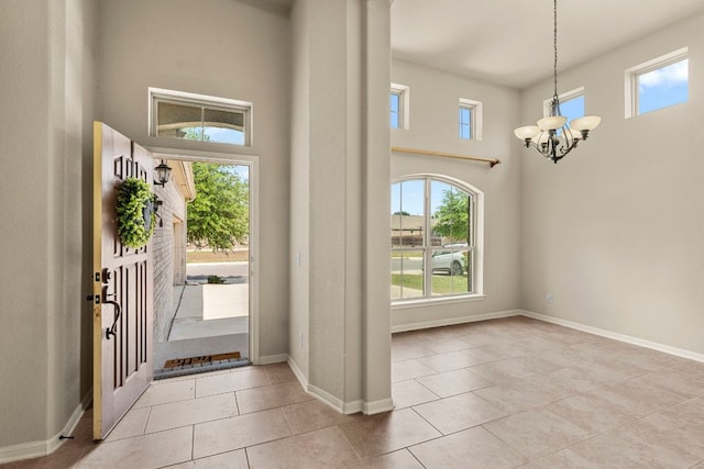entryway with a notable chandelier, tile patterned flooring, and plenty of natural light