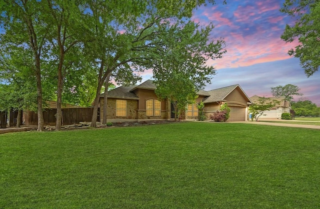 ranch-style home with a lawn, fence, concrete driveway, and an attached garage