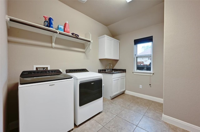 washroom featuring a sink, cabinet space, light tile patterned flooring, separate washer and dryer, and baseboards