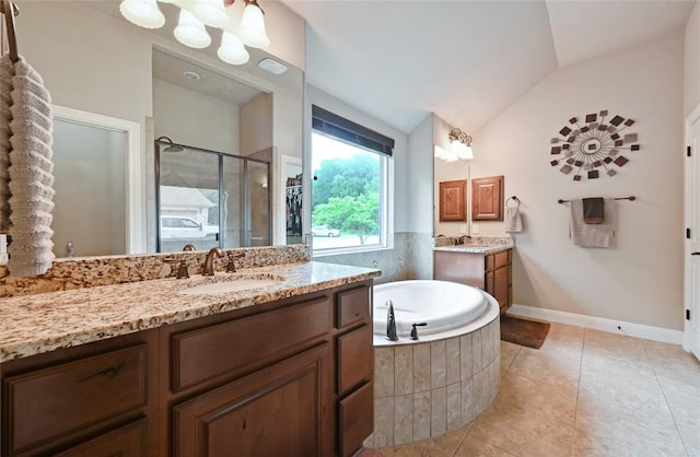 full bathroom featuring a sink, a shower stall, a bath, two vanities, and vaulted ceiling