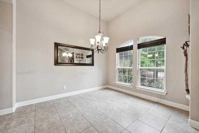 tiled empty room with high vaulted ceiling, a notable chandelier, and baseboards
