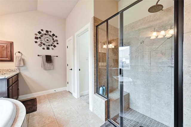 bathroom with baseboards, tile patterned flooring, a shower stall, vanity, and a relaxing tiled tub