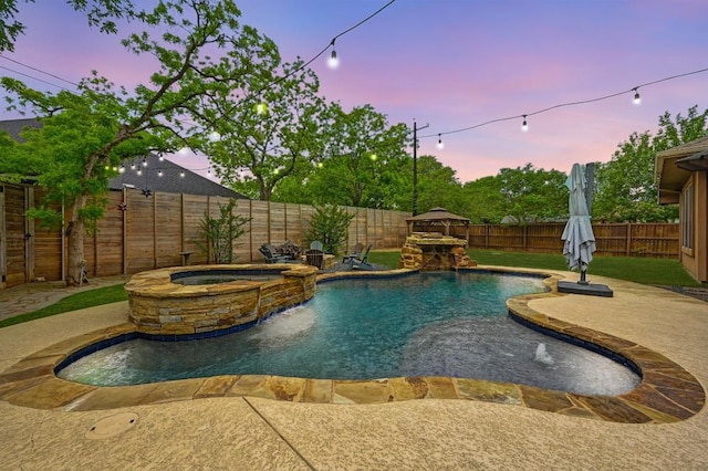 view of pool featuring a pool with connected hot tub, a fenced backyard, and a patio area