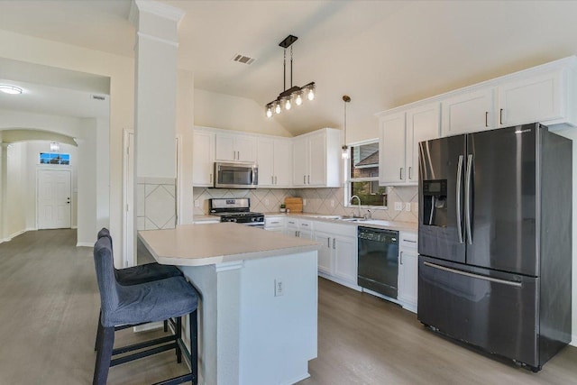 11805 Larch Valley Dr, Austin, TX 78754 - kitchen with fridge with ice dispenser, stainless steel microwave, black dishwasher, range with gas stovetop, and wood finished floors