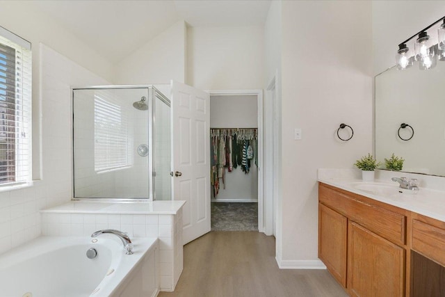 11805 Larch Valley Dr, Austin, TX 78754 - full bathroom featuring a stall shower, wood finished floors, vanity, a jetted tub, and a spacious closet