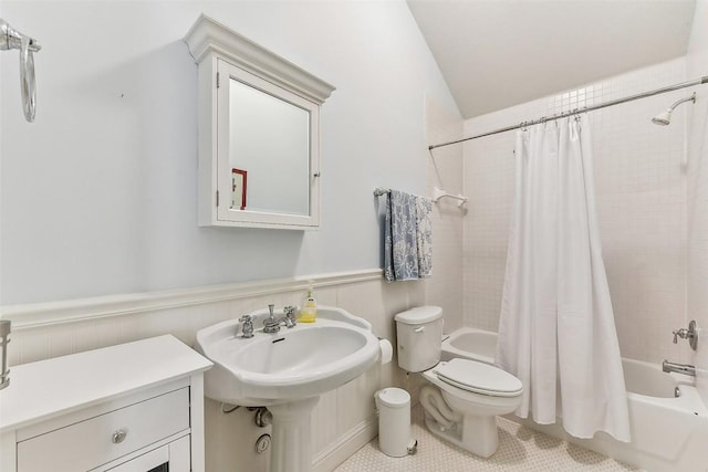 bathroom with shower / tub combo, a wainscoted wall, toilet, and tile patterned flooring