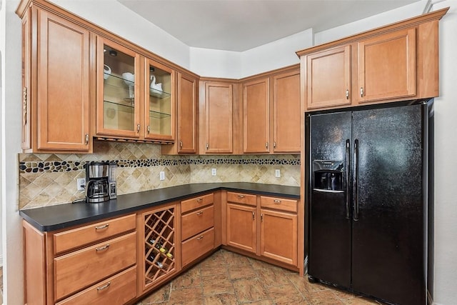5781 Fergus, Kyle, TX 78640 - kitchen with black fridge with ice dispenser, dark countertops, tasteful backsplash, glass insert cabinets, and stone finish floors