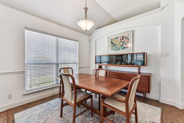 dining area with baseboards, vaulted ceiling, and plenty of natural light