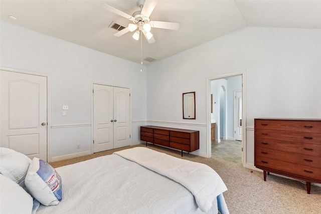 bedroom featuring visible vents, a closet, light colored carpet, and vaulted ceiling