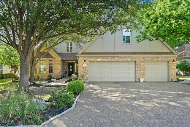 31009 La Quinta Dr, Georgetown, TX 78628 - view of front facade with driveway, board and batten siding, and brick siding